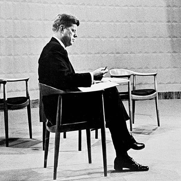 約翰·甘迺迪坐在丹麥現代風格大師 Hans Wegner 的椅子上。1960 年